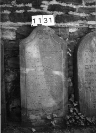 Grabstein 1131 (Index: 99630634) Material: Sandstein Zustand: leicht abgeblättert Maße HxBxT: 106x48x11 cm Beschreibung: Stele mit Konvexbogenabschluß: Grabstein 1131