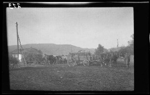 Odobești (=Rumänien): Zweispänner mit Leiterwagen und Heuwagen auf einem Platz, im Hintergrund eine Anhöhe (Distanzaufnahme) ("Kolonne")