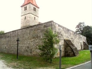 Ansicht von Nordosten mit Kirche (im Kern 14 Jh) über Kirchhofmauer (Steinbrüstung des Wehrgangs mit Schießscharten erhalten-hölzerner Laufgang und Regendach im 18 Jh entfernt)