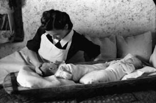 Bukarest: Institut für Ausbildung von Fürsorgeschwestern, Schwester versorgt Baby, liegend