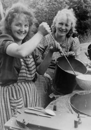 Scharbeutz-Pönitz. Die Köchinnen des Zeltlagers am Kochkessel. Mit einer großen Kelle wird Suppe in einen Eimer gefüllt