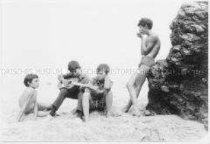 Jungen musizieren am Strand