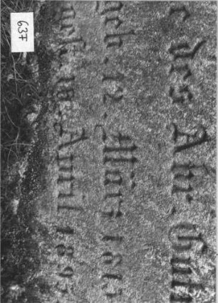 Grabstein 63 (Index: 99786687) Zustand: Inschrift oben rechts abgebrochen, z. T. verwittert, leicht eingesunken Maße HxBxT: 60x55x20 cm: Grabstein 63F