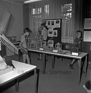 Ausstellung: Rathaus und Bürgerhaus Glinde [später Marcellin-Verbe-Haus]: Heimatverein Glinde: Mühlenmodelle auf Tischen: dazwischen Kinder und Erwachsene als Besucher