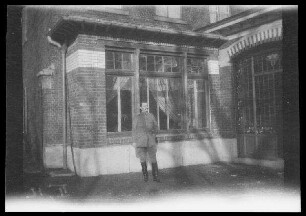 Comines (Dep. Nord, Frankreich): Offizier vor dem Eingang zu einem Backsteingebäude seitlicher Fensterfront (Distanzaufnahme) ("List (?) vor Kanzlei Comines")