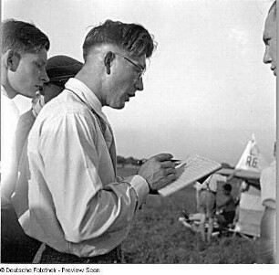Fluglehrer beim Eintragen der Tätigkeiten der einzelnen Flugschüler in ein Startbuch