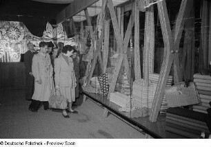 Besucher der Leipziger Herbstmesse 1954 vor einer Vitrine mit Textilien