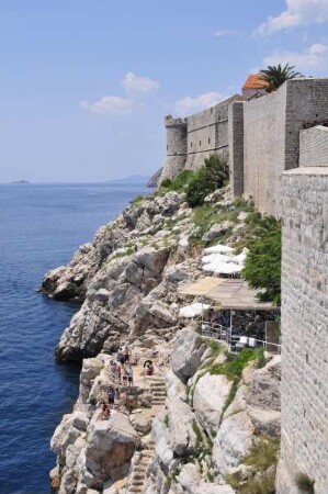 Dubrovnik - Felsen an der Mauer : Ausserhalb der Stadtmauer sonnen sich auf den Felsen Menschen. Aufgenommen am 2. Juli 2010 in Dubrovnik