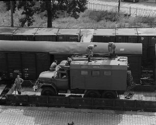 Verladung von Militärtechnik der 1. Gardepanzerarmee im Güterbahnhof Dresden-Neustadt. Soldaten verzurren Stabsbus auf einem Flachwagen : Dresden-Neustadt. Verladung von Militärtechnik der 1. Gardepanzerarmee im Güterbahnhof Dresden-Neustadt. Soldaten verzurren Stabsbus auf einem Flachwagen