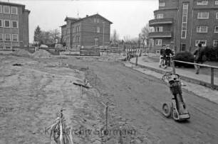 Bahnhofstraße: Baustelle mit Baugerät und Absperrungen: hinten Kreuzung mit Mewesstraße rechts, Ratzeburger Straße in der Mitte und Berliner Ring links: dahinter Häuser: rechts zwei Jugendliche auf Fahrrad und Frau