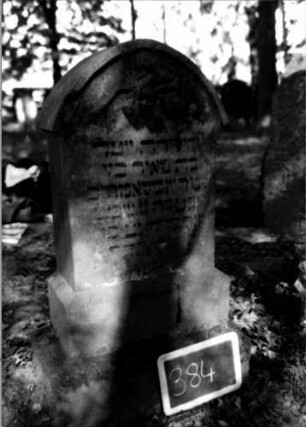 Grabstein 384 (Index: 100111853) Material: Sandstein Zustand: verwittert mit Textverlust Maße HxBxT: 105x47x22 cm Beschreibung: Stele, getreppter Sockel, Spitzbogenabschluß mit Verdachung Symbolik: geknickte Rose Besonderheit: Kindergrab: Grabstein 384