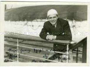 Schauspieler Gustav Fröhlich über die Reling des Hochseepassagierdampfers "Bremen" gelehnt, mit Autograph