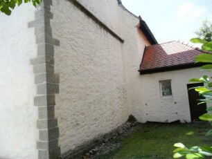 Kirchturm im Norden mit Erdgeschoß und Langhausansatz (beachte Mauerstärkenversatz) über Kirchhof