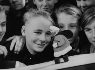 Jungen betrachten einen Weihnachtsmann (Szene aus der DEFA-Wochenschau "Der Augenzeuge" ?)