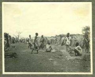 Afrikanische Träger, Askaris und Angehörige des Trosses in einem Hüttenlager