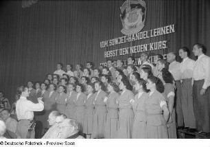 Gemischter Chor und Chorleiter auf der Bühne bei einer Kulturveranstaltung der Gewerkschaft Handel