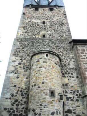 Evangelische Kirche - Kirchturm (frühgotisch 13 Jhd) von Süden mit Treppenturm zum unteren Mittelgeschoß und Schießscharten (Schlitzscharten) sowie Werksteinen im Mauersteinverband