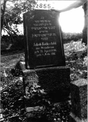 Grabstein 855 (Index: 99802446) Material: Granit, poliert Zustand: sehr gut Maße HxBxT: 139x50x18 cm Beschreibung: Sockel, Stele mit Flachbogenabschluß, Inschriftenfeld mit eingezogenem Rundbogen Symbolik: Blattwerk Besonderheit: Endreim: Grabstein 855
