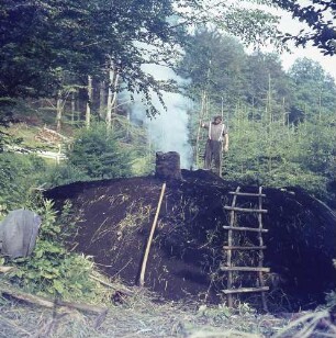 Ein Köhler im Odenwald an seinem anbrennendem Meiler bei Gaimühle