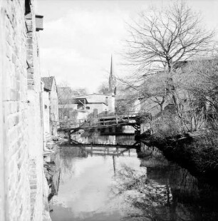 Trave: Stadtarm hinter Hindenburgstraße: Blick von der Brücke "Hamburger Torbrücke" an der Hagenstraße Richtung Peter-Paul-Kirche: links und hinten Gebäude: rechts Garten: hinten Mitte Fußgängerbrücke