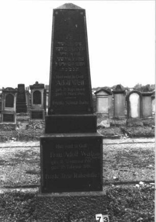 Grabstein 73 (Index: 99808335) Material: Granit Zustand: gut Maße HxBxT: 220x56x56 cm Beschreibung: Obelisk, getreppter Sockel Symbolik: Blümchen Besonderheit: Doppelgrab: Grabstein 73