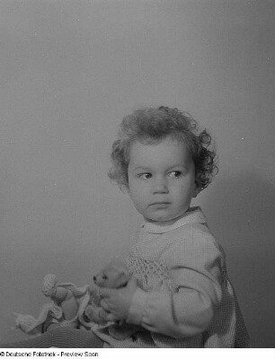 Porträt eines kleinen Mädchens mit Puppe und Teddybär