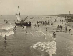 Ahlbeck. Badende am Ostseestrand. Links im Bild ein Zeesenboot