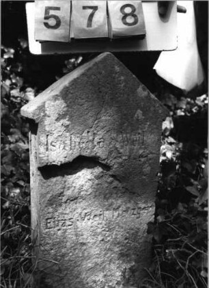 Grabstein 578 (Index: 99789073) Material: Sandstein Zustand: sehr stark verwittert mit Textverlust Maße HxBxT: 75x36x10 cm Besonderheit: Kindergrab; - (Foto unscharf): Grabstein 578