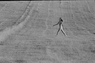 Čičmany. Akt-Pleinair 1980. Abgeerntetes Feld mit einer darüber laufenden jungen Frau