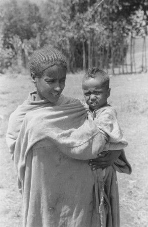 Frau der Amhara : Junge Amhara-Frau vor ihrer Hütte. Im Arm ein Kind
