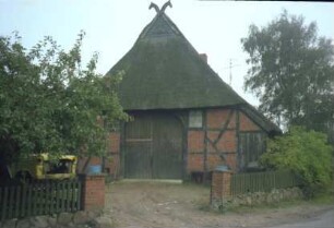 Wiesenstraße: Fachwerkkate mit Reetdach: Pferdeköpfe als Giebelzier: Giebelfront Wirtschaftstrakt mit Scheunentor: Auffahrt, Gartenzaun, Straße
