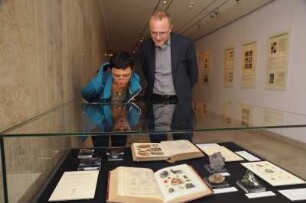 SLUB, Ausstellung "Gespräche mit der Erde. Geowissenschaften in Sachsen" : Ausstellungseröffnung am 14. Oktober 2014 im Vortragssaal. Gäste an einer Ausstellungsvitrine im Buchmuseum