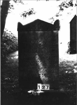 Grabstein 127 (Index: 100085492) Maße HxBxT: 102x58x11 cm Beschreibung: Stele, profilierter Sockel, giebelartiger Abschluß mit Eckakroteren, Zahnfries: Grabstein 127