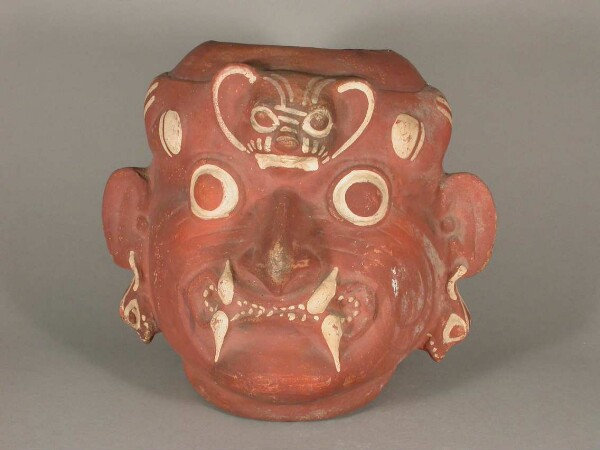 Anthropo-zoomorphic head with feline teeth