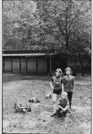 Drei Kinder auf einem Hinterhof