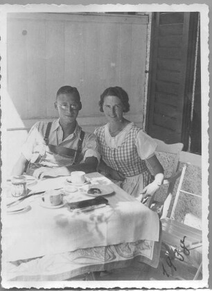 Paar am Frühstückstisch im Freien - Mann in Lederhosen, Frau im Dirndl