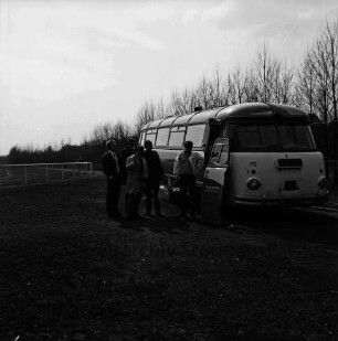 Kurparkstadion: vorn rechts Umkleidebus: links davor vier Sportler: hinten Sportplatz
