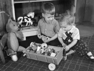 Kinderbilder. Zwei kleine Jungen mit Spielzeug