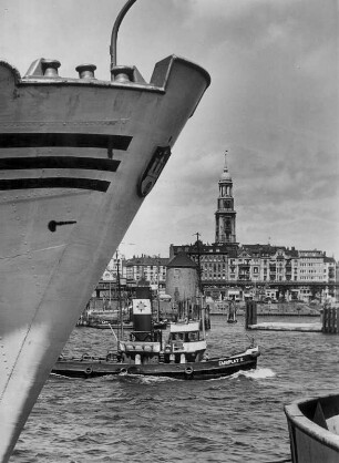 Hamburg. Blick vom Reiherstieg Richtung Hauptkirche St. Michaelis. Im Vordergrund der Bug eines Schiffes und ein Schlepper