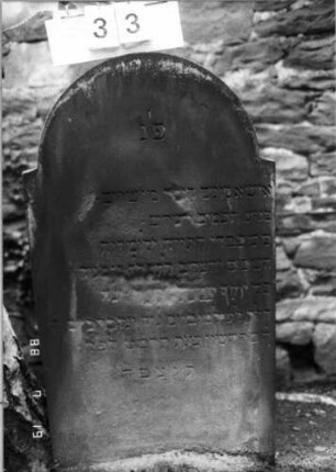Grabstein 33 (Index: 100094877) Material: Sandstein Zustand: Stücke herausgebrochen mit Textverlust Maße HxBxT: 118x68x9 cm Beschreibung: Stele, schräg eingezogener Rundbogenabschluß: Grabstein 33