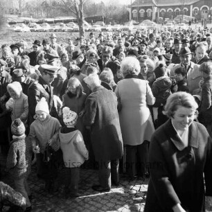 Schlosspark: Ostereiersuchen: Mitglieder des Bürgervereins verteilen am Eingang auf der Schlossbrücke Tüten mit Süßigkeiten an Kinder: Besucher: im Hintergrund rechts Marstall