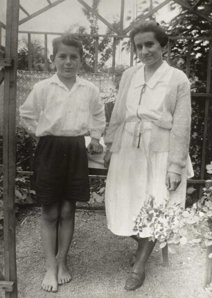 Mutter mit Sohn in einer Gartenlaube stehend