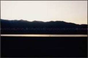Küstenlandschaft in der Dämmerung mit Felsmassiv im Hintergrund (Altersgruppe 14-17)