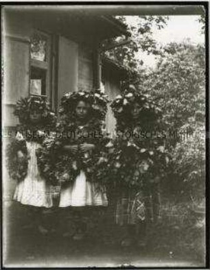 Mädchen mit Laubkränzen im Garten