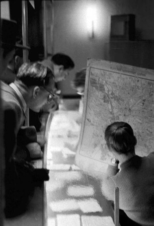 Rechercheteam vor einem Stadtplan der Messestadt Leipzig