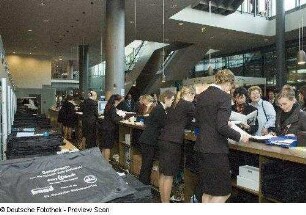 Hostessen und Tagungsteilnehmer bei der Anmeldung