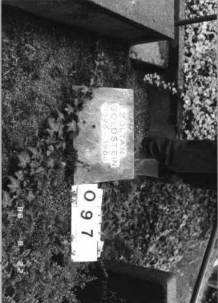 Grabstein 97 (Index: 100080265) Material: Kunststein? Zustand: gut Maße HxBxT: 37x43x6 cm Beschreibung: schräg aufgestellte Bodebplatte: Grabstein 97