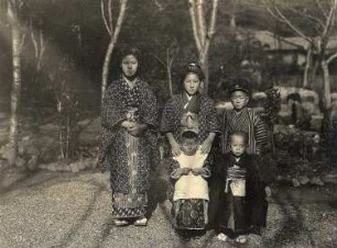 Weltreisen. Japanische Kinder. Gruppenbild mit zwei Mädchen und drei Knaben in traditioneller Kleidung vor einem Hausgarten in Nagasaki