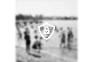 Freibad Poggensee: Badegäste am Sandstrand und im Wasser, im Hintergrund der Badesteg