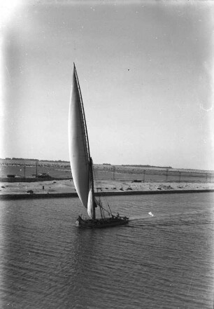 Segelboot : Ein Segelboot auf dem Sueskanal. In Hintergrund das Ufer mit einer Bahnlinie.